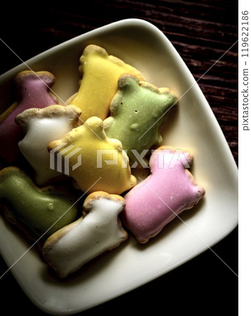 Four colored icing cookies on a white plate 119622186