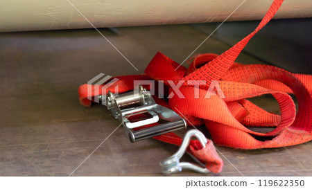 A lashing strap thrown onto the floor of the truck body 119622350