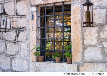 Rustic window with metal bars and potted plants. Montenegro 119622864