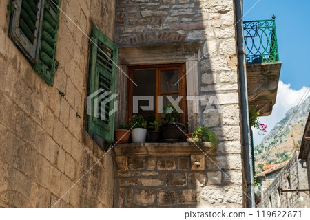 Rustic stone building with plants on windowsill 119622871