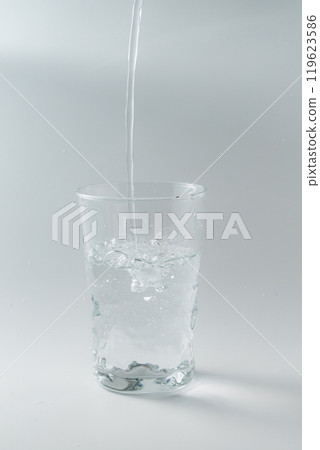 Pouring water into a simple glass Pouring water into a simple glass 119623586