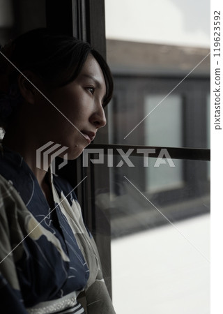 一個穿著浴衣的女人站在格子門旁 一個穿著浴衣的女人站在格子門旁 119623592
