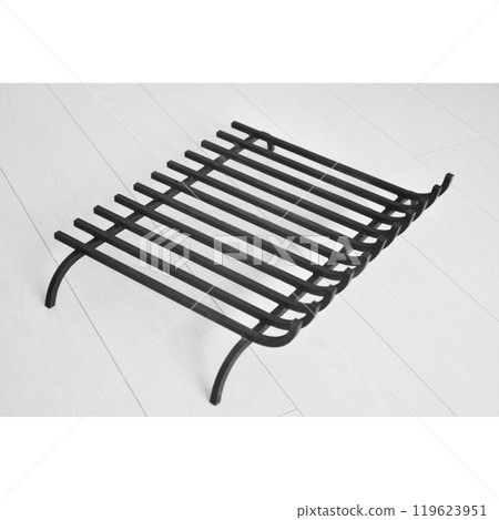 An object photo shoot of black grilles for fireplaces on a light background in the interior. 119623951