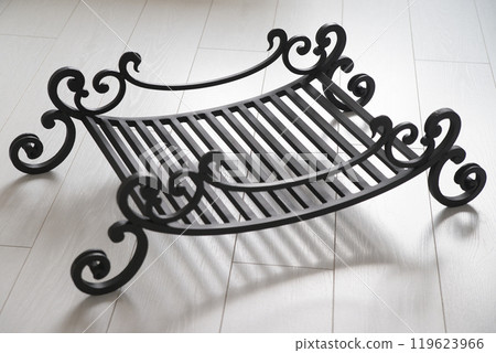 An object photo shoot of black grilles for fireplaces on a light background in the interior. 119623966