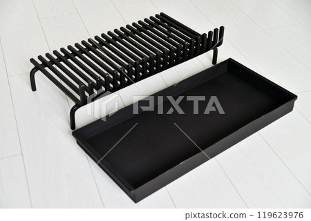 An object photo shoot of black grilles for fireplaces on a light background in the interior. 119623976
