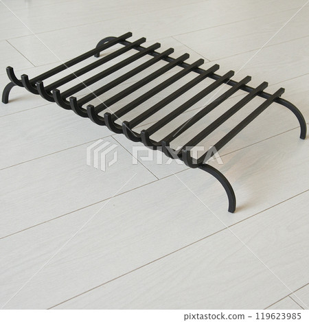 An object photo shoot of black grilles for fireplaces on a light background in the interior. An object photo shoot of black grilles for fireplaces on a light background in the interior. 119623985
