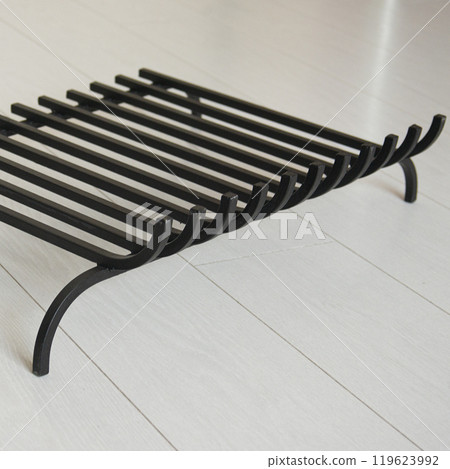 An object photo shoot of black grilles for fireplaces on a light background in the interior. An object photo shoot of black grilles for fireplaces on a light background in the interior. 119623992