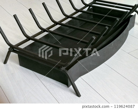 An object photo shoot of black grilles for fireplaces on a light background in the interior. 119624087