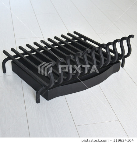 An object photo shoot of black grilles for fireplaces on a light background in the interior. 119624104