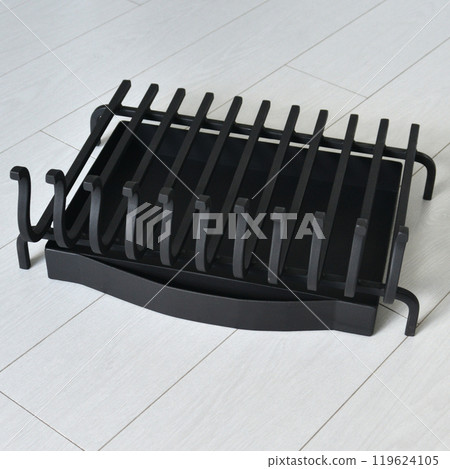 An object photo shoot of black grilles for fireplaces on a light background in the interior. 119624105
