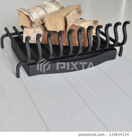 An object photo shoot of black grilles for fireplaces on a light background in the interior. An object photo shoot of black grilles for fireplaces on a light background in the interior. 119624114