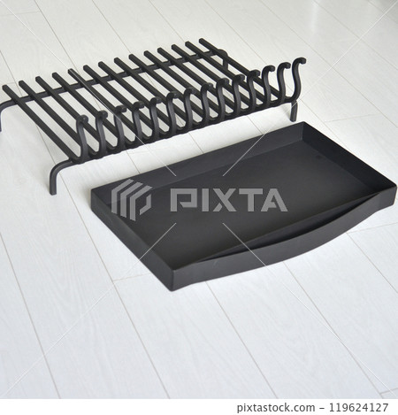 An object photo shoot of black grilles for fireplaces on a light background in the interior. An object photo shoot of black grilles for fireplaces on a light background in the interior. 119624127