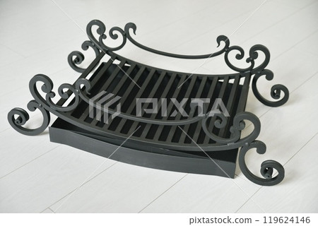 An object photo shoot of black grilles for fireplaces on a light background in the interior. An object photo shoot of black grilles for fireplaces on a light background in the interior. 119624146