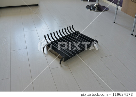 An object photo shoot of black grilles for fireplaces on a light background in the interior. 119624178