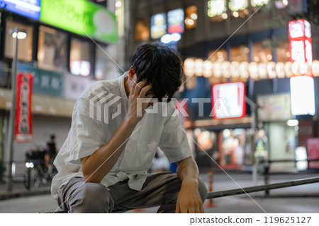 Man holding his head on the street Man holding his head on the street 119625127