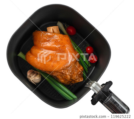 delicious pork knuckle prepared in airfryer no fat by circulating hot air inside the basket isolated on white background, concept of German cuisine 119625222