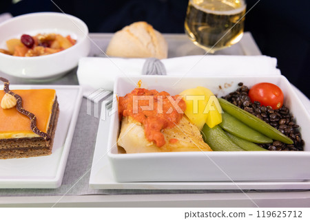 Delicious business class meal: halibut fish with vegetables, champagne and chocolate cake 119625712