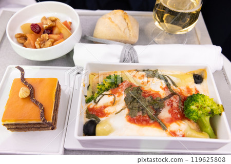 Delicious Business Class meal: Ricotta and spinach cannelloni with champagne and chocolate cake 119625808