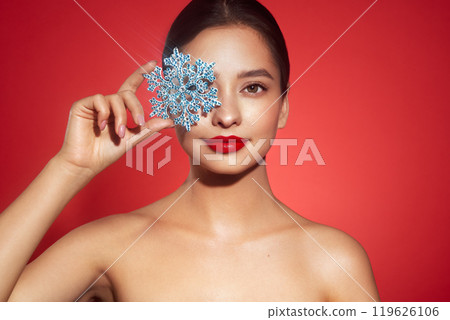 Beautiful young woman with glowing snowflake 119626106