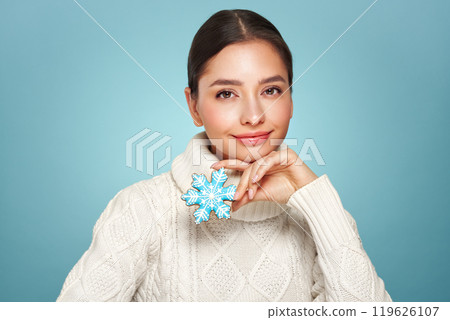 Woman in a white knitted sweater with cookie Snowflake Woman in a white knitted sweater with cookie Snowflake 119626107