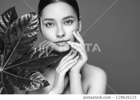 Close up woman face with green exotic leaf Close up woman face with green exotic leaf 119626115