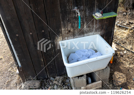 Outdoor washing station with faucet and basin on wooden wall Outdoor washing station with faucet and basin on wooden wall 119626254