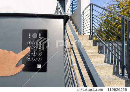 Hand using keypad on modern security system by stairs Hand using keypad on modern security system by stairs 119626256