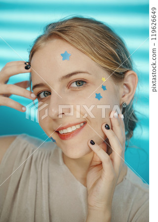 Smiling Woman with Star Stickers on Her Face 119626649