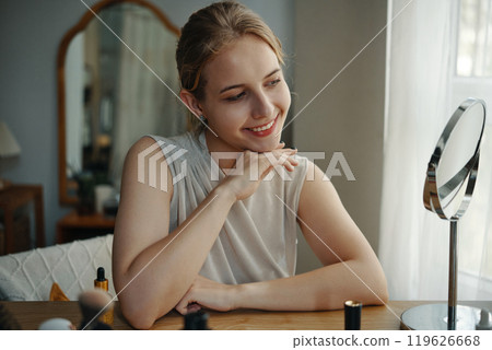 Smiling Woman Admiring Reflection in Bedroom Mirror 119626668