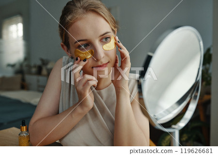 Applying Gold Eye Patches for Soothing Skin Care Routine 119626681