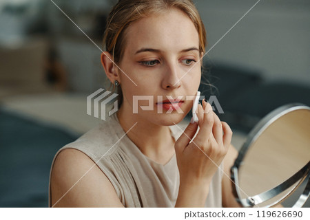 Applying Makeup in Front of a Handheld Mirror 119626690