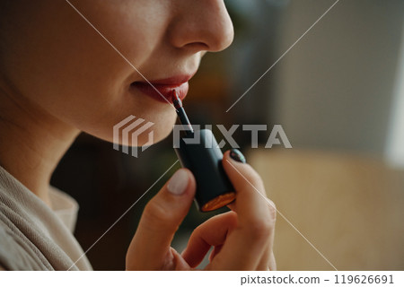 Applying Makeup with a Lip Gloss Wand in Hand Applying Makeup with a Lip Gloss Wand in Hand 119626691