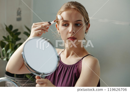Young Woman Applying Makeup in Modern Interior 119626706