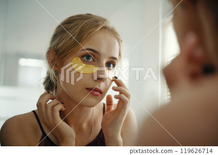 Woman Applying Skincare Patch Under Eye Woman Applying Skincare Patch Under Eye 119626714