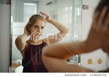 Combing Hair in Bathroom Mirror Reflection Combing Hair in Bathroom Mirror Reflection 119626716