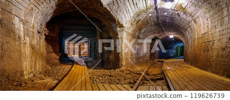Old underground mine tunnel with wooden walkways and arched stone walls, cooper mine 119626739