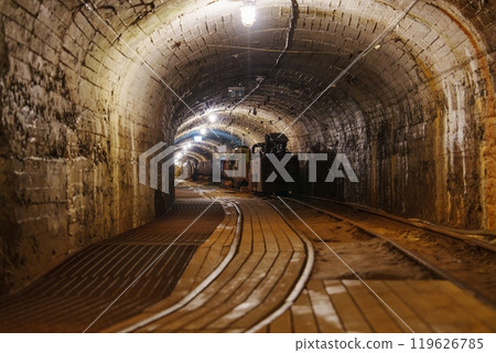A Dark, Spooky Abandoned Mine Tunnel with Rusty Rails and Stone Walls Evoking Eerie Memories, gold mine 119626785