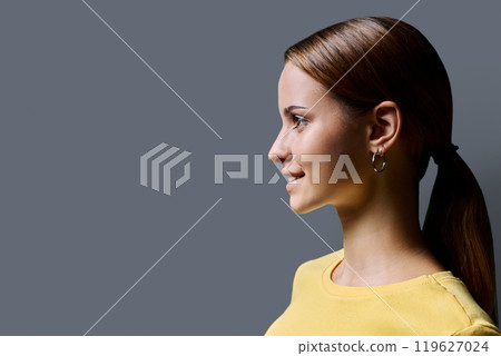 Headshot portrait in profile beautiful smiling young woman with red hair on gray background Headshot portrait in profile beautiful smiling young woman with red hair on gray background 119627024