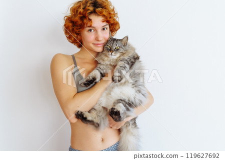 portrait red-haired teenage girl with gray fluffy cat portrait red-haired teenage girl with gray fluffy cat 119627692