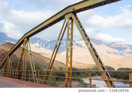View of an old iron bridge with mountains in the background in Salta, Argentina. View of an old iron bridge with mountains in the background in Salta, Argentina. 119628056