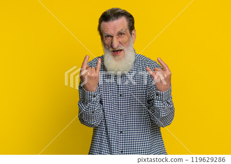Happy senior man showing rock n roll gesture by hands cool sign crazy expression dancing victory win 119629286