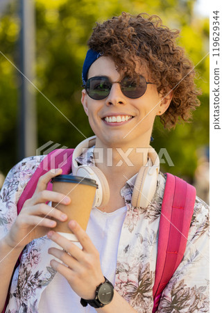 Smiling man tourist enjoying morning coffee hot drink relaxing, taking a break on urban city street Smiling man tourist enjoying morning coffee hot drink relaxing, taking a break on urban city street 119629344