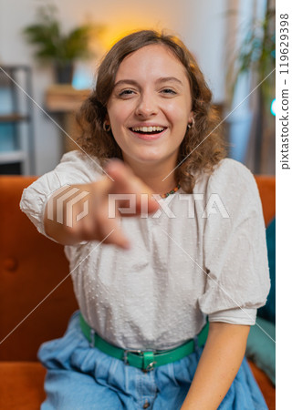 Young woman laughing out loud after hearing ridiculous funny joke sitting on sofa couch at home Young woman laughing out loud after hearing ridiculous funny joke sitting on sofa couch at home 119629398