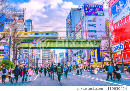 Tokyo cityscape in Japan: Two trains... Akihabara pedestrian precinct and the Sobu line bustling with foreign tourists. Express train in the background = 18th Tokyo cityscape in Japan: Two trains... Akihabara pedestrian precinct and the Sobu line bustling with foreign tourists. Express train in the background = 18th 119630424