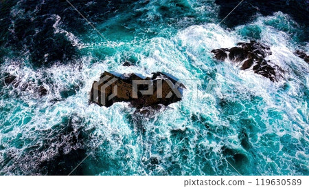 Stunning Aerial View of Vibrant Turquoise Waves Elegantly Crashing Against Rocky Shoreline Stunning Aerial View of Vibrant Turquoise Waves Elegantly Crashing Against Rocky Shoreline 119630589