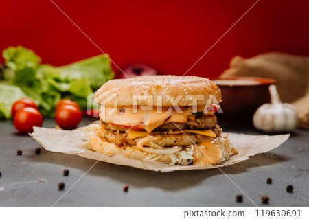 Double-layered chicken burger with melted cheese and fresh toppings Double-layered chicken burger with melted cheese and fresh toppings 119630691
