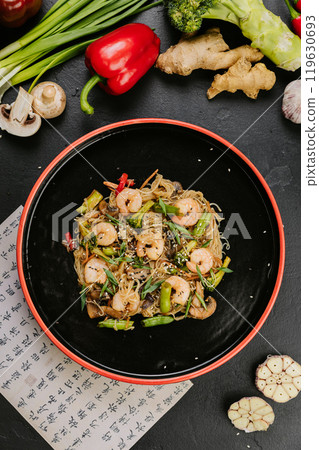Stir-fried chicken with vegetables and glass noodles, garnished with sesame seeds for a healthy meal Stir-fried chicken with vegetables and glass noodles, garnished with sesame seeds for a healthy meal 119630693