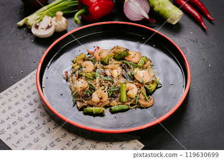 Stir-fried chicken with vegetables and glass noodles, garnished with sesame seeds for a healthy meal Stir-fried chicken with vegetables and glass noodles, garnished with sesame seeds for a healthy meal 119630699