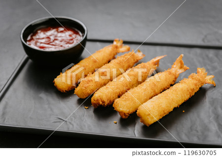 Golden fried shrimp sticks with crispy breading and dipping sauce. Perfect for appetizers or snacks 119630705