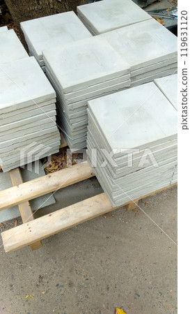 Stacked concrete slabs on wooden pallets in an outdoor setting. 119631120